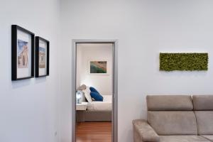 a living room with a couch and a mirror at Suite San Biagio in Lecce