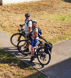 two people standing with their bikes on a road at ViaRhona cocooning room Frei Zimmer in Valleiry