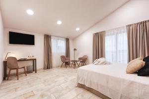 a bedroom with a bed and a desk and a television at Hotel rural La Tejera in Quintanilla de Arriba