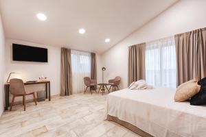 um quarto com uma cama, uma secretária e uma televisão em Hotel rural La Tejera em Quintanilla de Arriba