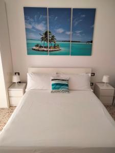 マルツァメミにあるIl Piccolo Portoのベッドルーム1室(ヤシの木が2本立つ白いベッド1台付)