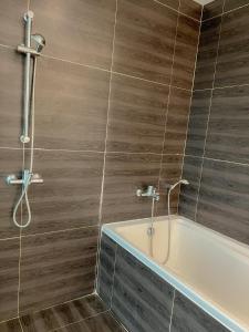 a bathroom with a shower and a bath tub at Feel Like Home Pool Villa Pattaya in Jomtien Beach