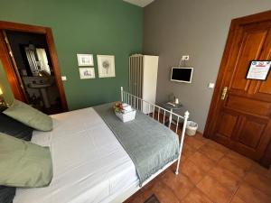 a bedroom with a white bed and a refrigerator at Hostal Casa San Nicolas in Molinaseca