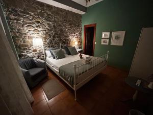 a bedroom with a bed and a stone wall at Hostal Casa San Nicolas in Molinaseca