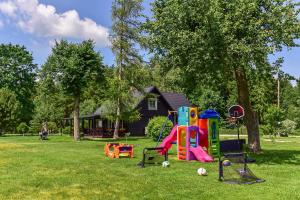 a group of playground equipment in a yard with a house at Vila Loreta - namelis su pirtimi in Dūdorynė