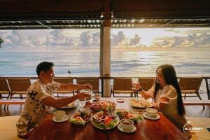 two people sitting at a table with plates of food at Kacha Resort & Spa, Koh Chang in Ko Chang