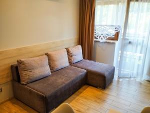 a couch with two pillows sitting in a living room at Willa STRITZKI in Wisła