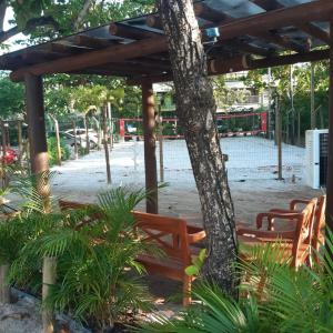 - un groupe de chaises et un arbre dans un pavillon dans l'établissement Triplex 3 Quartos Praia do Forte Ba, à Praia do Forte