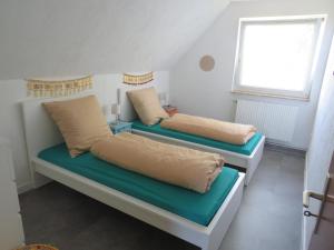 two beds with pillows on them in a room at Ferienhaus PH 17 in Krummhörn