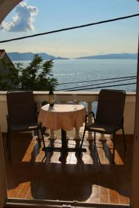 a table and chairs on a balcony with a view of the ocean at Apartman Mara in Sveti Juraj