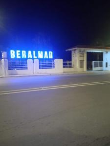 ein Gebäude mit einem Schild, das nachts Benallaarma liest in der Unterkunft Beralmar Asilah Chez FATIMA in Asilah