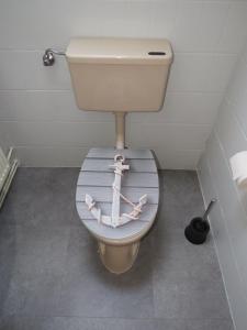a bathroom with a toilet with a anchor on the lid at Ferienhaus PH 17 in Krummhörn +33 photos
