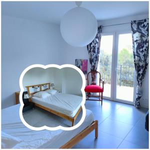 a bedroom with a white bed and a red chair at Villa Coco avec jardin piscine et terrain de boules de 180 m carrés in Les Arcs sur Argens