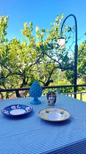 une table avec deux assiettes et un vase sur elle dans l'établissement Hotel Villa Degli Aranci, à Maratea