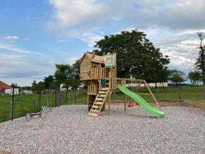 um parque infantil de madeira com escorrega num parque em Chalet avec spa, Au Bois Quartois em La Quarte
