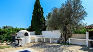 un jardín con una valla blanca y un árbol en Can Anadï, en Sant Jordi