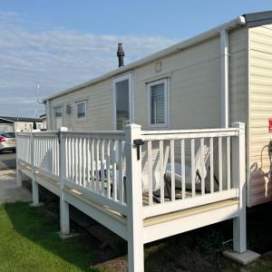 a house with a white porch with a white fence at CASALIE at Seasalter Whitstable in Seasalter
