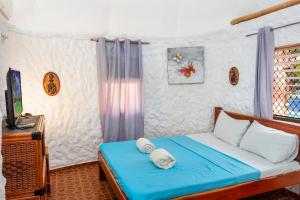 a bedroom with a bed with towels on it at Panglao Chocolate Hills Resort in Panglao Island