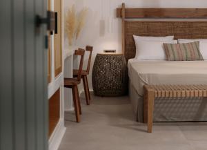 a bedroom with a bed and a table and a chair at "Makava Suites" Your Luxe Urban Sanctuary in Naxos Chora