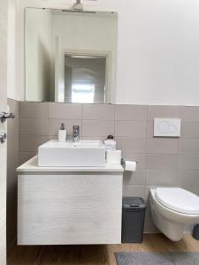 bagno bianco con lavandino e servizi igienici di Roof Pellegrini a Verona