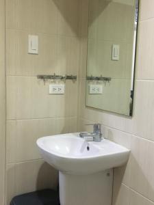 a bathroom with a white sink and a mirror at 1 Bedroom US Embassy Roxas Blvd. Ermita Manila in Manila