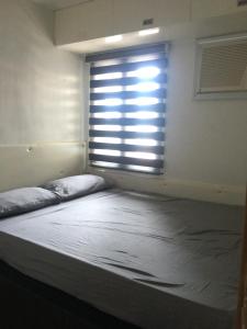 a bed in a room with a large window at 1 Bedroom US Embassy Roxas Blvd. Ermita Manila in Manila