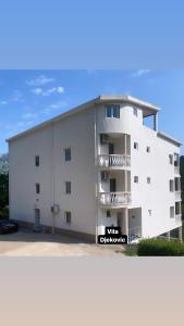 a white building with a sign that reads vita disney at Villa Djekovic in Čanj
