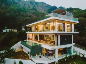 a large house with a swimming pool in front of it at Villa Nordic Star Seaview Near Kata Beach in Kata Beach