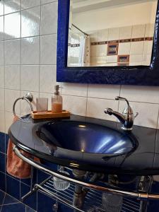 baño con lavabo negro y espejo en Florina House - Spacious with 2 Bedrooms and mountain view, en Florina