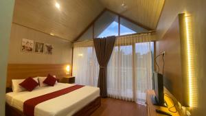 a bedroom with a bed and a large window at Rautani Sembalun in Sembalun Lawang