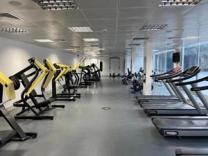 a gym with a row of treadmills and machines at I Like Al Hamra Palace - Elite Beach & Golf Resort Private Suites in Ras al Khaimah