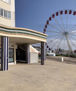 a ferris wheel in front of a building next to a wheel at Studio 50 m de la plage 100 m centre ville in Berck-sur-Mer