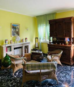 - un salon avec un piano et des chaises en osier dans l'établissement Hotel Villa Degli Aranci, à Maratea