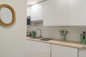 biała kuchnia ze zlewem i lustrem w obiekcie Lavie Maison Paris AC Retreat w Paryżu +3 zdjęcia