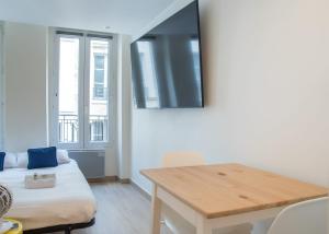 - un salon avec une table et un canapé dans l'établissement Lavie Maison Paris AC Retreat, à Paris