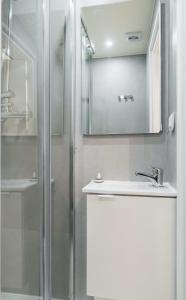 La salle de bains est pourvue d'une douche, d'un lavabo et d'un miroir. dans l'établissement Lavie Maison Paris AC Retreat, à Paris