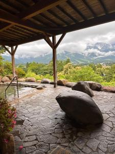 a large rock sitting on a patio with a hot tub at FLYING HOUSE in Chikuni