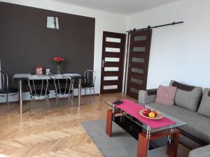 sala de estar con sofá, mesa y sillas en Travel Apartament Cracow en Cracovia