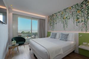 a bedroom with a bed and a large window at Olivi Hotel & Natural Spa in Sirmione