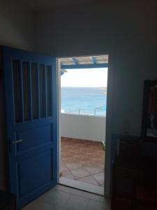 eine offene Tür zu einem Zimmer mit Meerblick in der Unterkunft Aigaio studios & rooms in Azolimnos