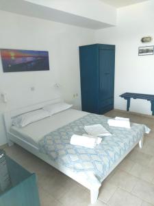 a bedroom with a bed with a blue cabinet and a table at Aigaio studios & rooms in Azolimnos