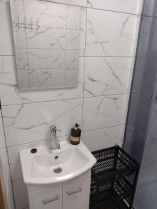 W białej łazience znajduje się umywalka i lustro. w obiekcie Villa na Chabrowej w mieście Miedziana Góra