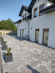 a patio with potted plants in front of a house at Villa na Chabrowej in Miedziana Góra