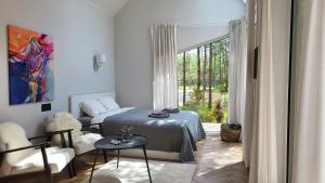 sypialnia z łóżkiem, kanapą i oknem w obiekcie WUUD Pädaste w mieście Simisti