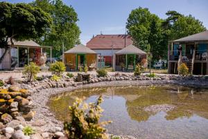 ミエルノにあるHerbals - Tree&Lake houses with bath, sauna, bikesの建物前の池付庭園