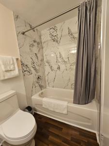 uma casa de banho com uma banheira, um WC e um chuveiro em Sunflower Guest Suites em Summerside