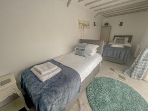 a bedroom with two beds with towels on them at Meadow Barn - stunning Norfolk holiday home sleeping 8 - under 3 miles to the coast in Knapton