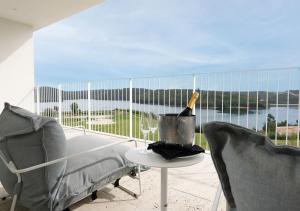 Una botella de vino sentada en una mesa en un balcón en Montebelo Aguieira Lake Resort & Spa, en Mortágua