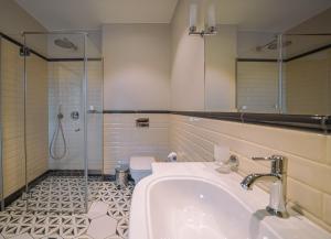 een badkamer met een douche, een wastafel en een bad bij Royal Horse Resort 