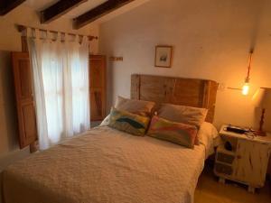 uma cama com duas almofadas e uma janela num quarto em Chalet con piscina privada em Blanca